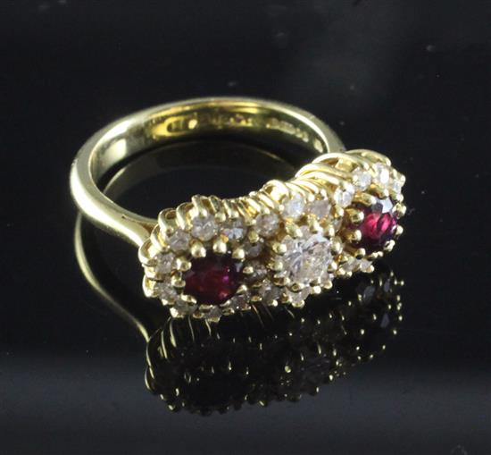 An 18ct gold ruby and diamond triple cluster ring, size K.